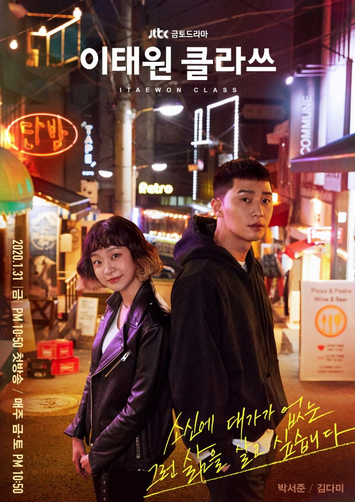 A promotional image for the drama 'Itaewon Class' featuring two characters standing together in a vibrant street with colorful neon lights.
