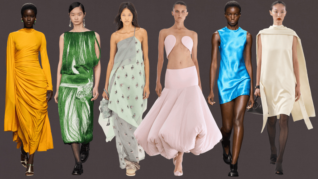 A lineup of six models showcasing various fashion designs, featuring vibrant colors and diverse styles including a yellow gown, green draped dress, light green patterned outfit, pink strapless dress, blue sleeveless dress, and an elegant off-white cape dress.